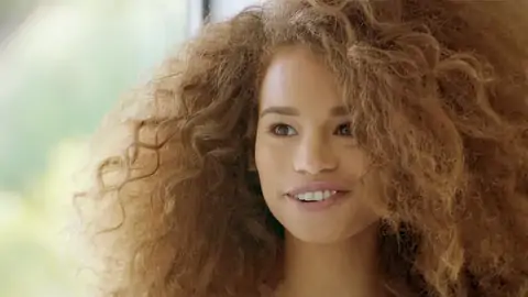 Teenage dark-hued with wavy hair is railing a gigantic meatpipe on the bed