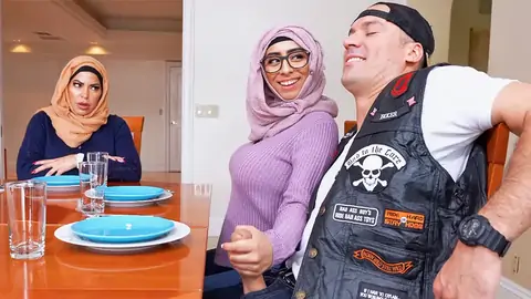 Hijab-wearing doll giving a hand-job from under the table